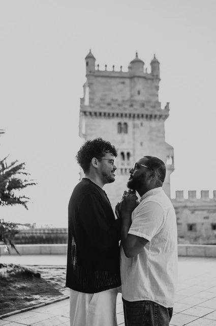 A close tower portrait in black and white | Lisbon couple photoshoot A black-and-white close portrait of the couple leaning towards each other beside Belém Tower during their couple photoshoot in Lisbon.