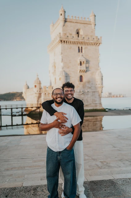 A close embrace beside the tower | Lisbon couple photoshoot A portrait of the couple smiling together in a close embrace in front of Belém Tower during their couple photoshoot in Lisbon.