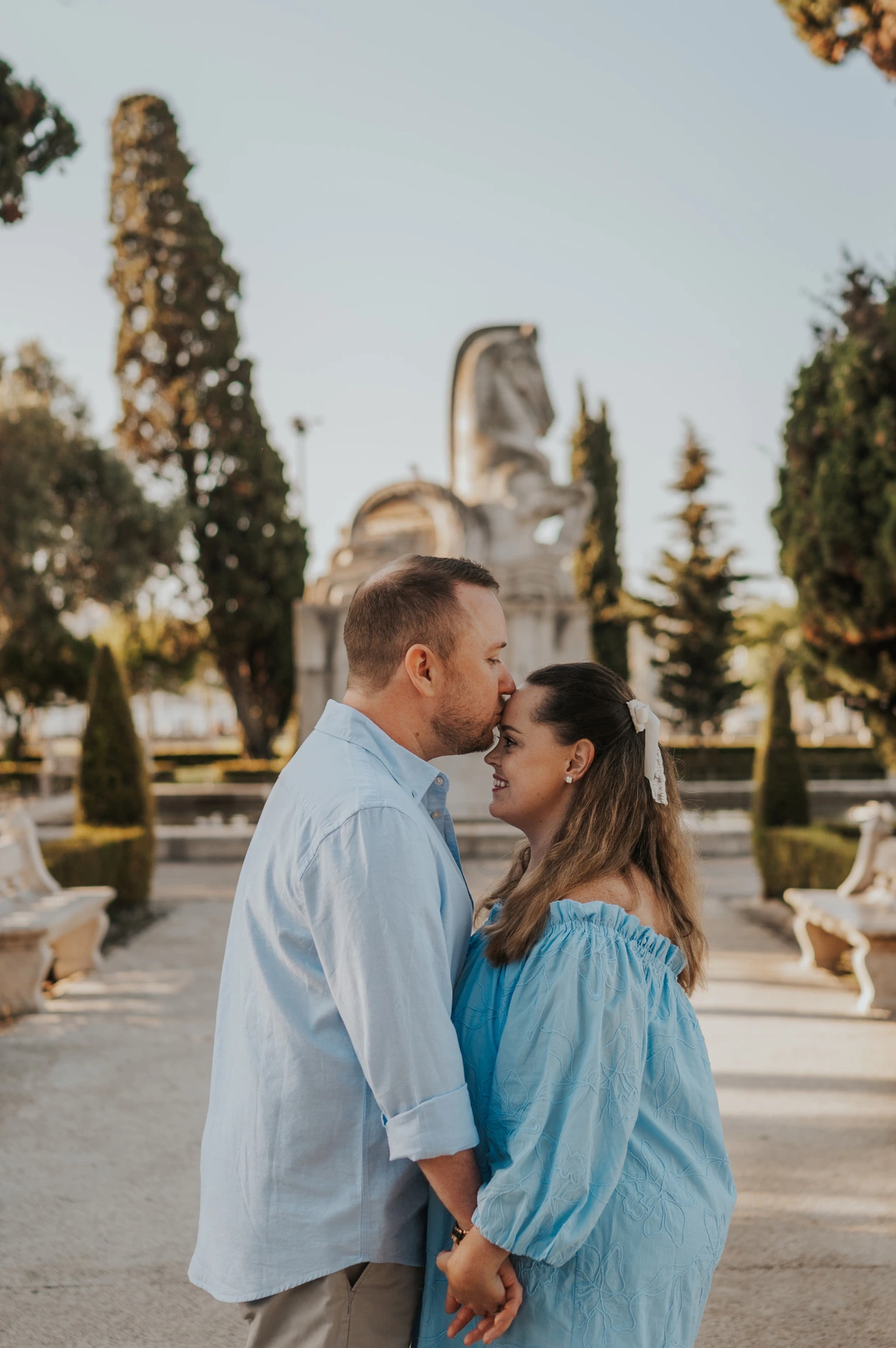 The couple leaning towards each other for a close portrait in the garden during their engagement photoshoot in Lisbon.