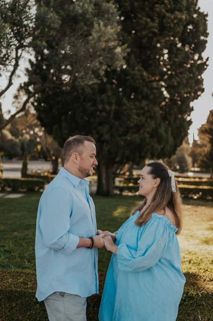 Joined hands in the gardens | Lisbon engagement photoshoot The couple facing each other and holding hands beneath the garden trees during their engagement photoshoot in Lisbon.