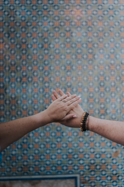 Joined hands against the tiles | Lisbon engagement photoshoot A close detail of the couple’s joined hands against the patterned tile wall during their engagement photoshoot in Lisbon.