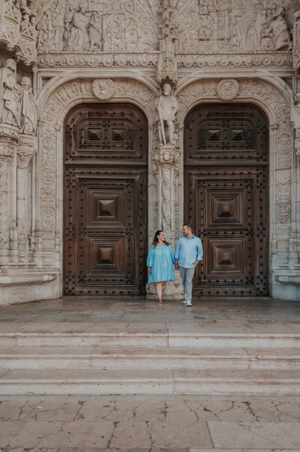 Hand in hand on the monastery steps | Lisbon engagement photoshoot The couple holding hands and moving together on the steps outside Jerónimos Monastery during their engagement photoshoot in Lisbon.
