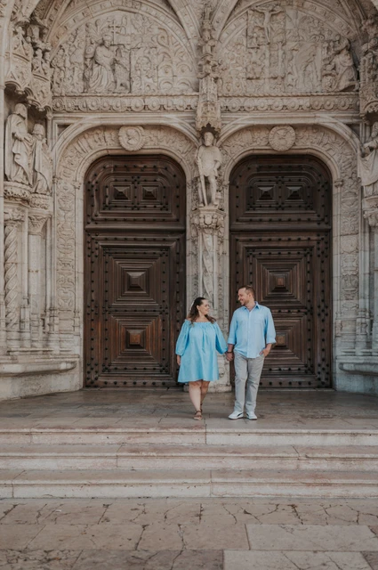 Hand in hand on the monastery steps | Lisbon engagement photoshoot The couple holding hands and moving together on the steps outside Jerónimos Monastery during their engagement photoshoot in Lisbon.