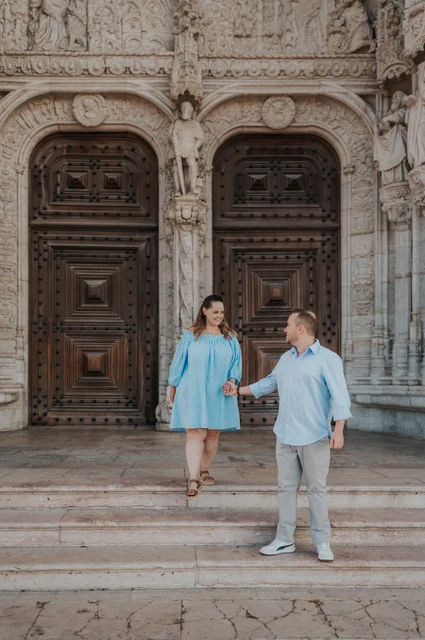 Hand in hand on the monastery steps | Lisbon engagement photoshoot The couple holding hands and moving together on the steps outside Jerónimos Monastery during their engagement photoshoot in Lisbon.