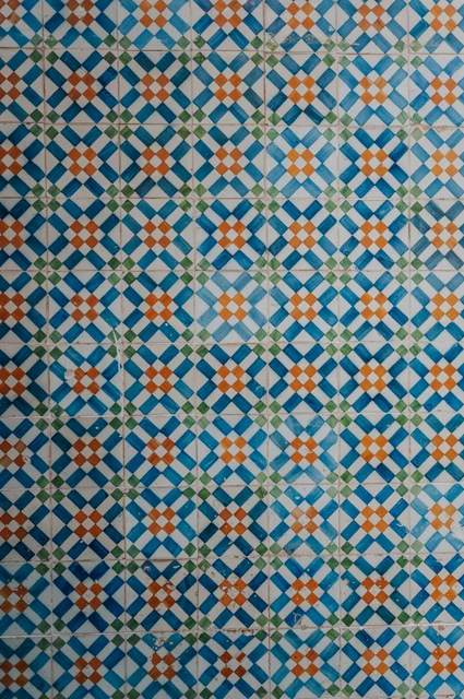 The patterned tiles at Belém | Lisbon engagement photoshoot A close view of the blue, white and yellow patterned tile wall during their engagement photoshoot in Lisbon.