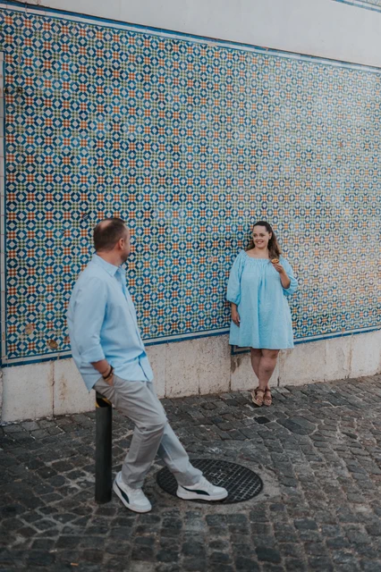 A wide portrait along the tile wall | Lisbon engagement photoshoot The couple leaning apart against the long patterned tile wall during their engagement photoshoot in Lisbon.