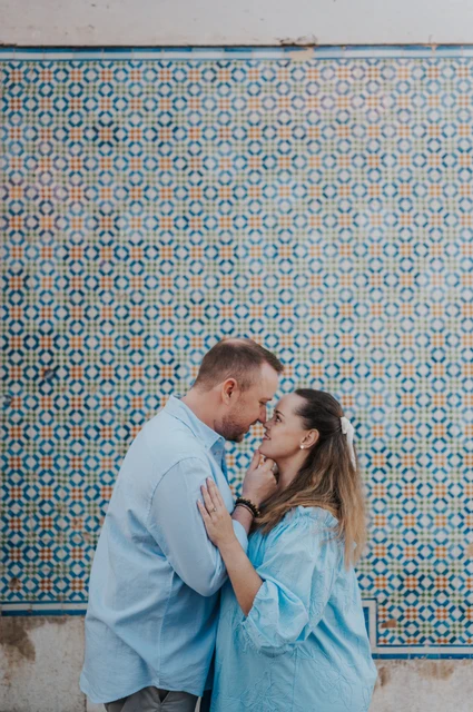 A kiss beside the patterned tiles | Lisbon engagement photoshoot The couple leaning together for a kiss in front of the patterned tile wall during their engagement photoshoot in Lisbon.