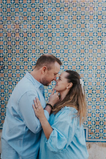 A kiss beside the patterned tiles | Lisbon engagement photoshoot The couple leaning together for a kiss in front of the patterned tile wall during their engagement photoshoot in Lisbon.
