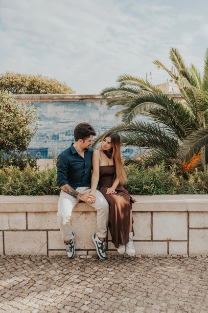 A forehead kiss beside the blue tiles | Lisbon engagement photoshoot A forehead kiss as the couple sit beside the blue tiled wall at Santa Luzia during their engagement photoshoot in Lisbon.