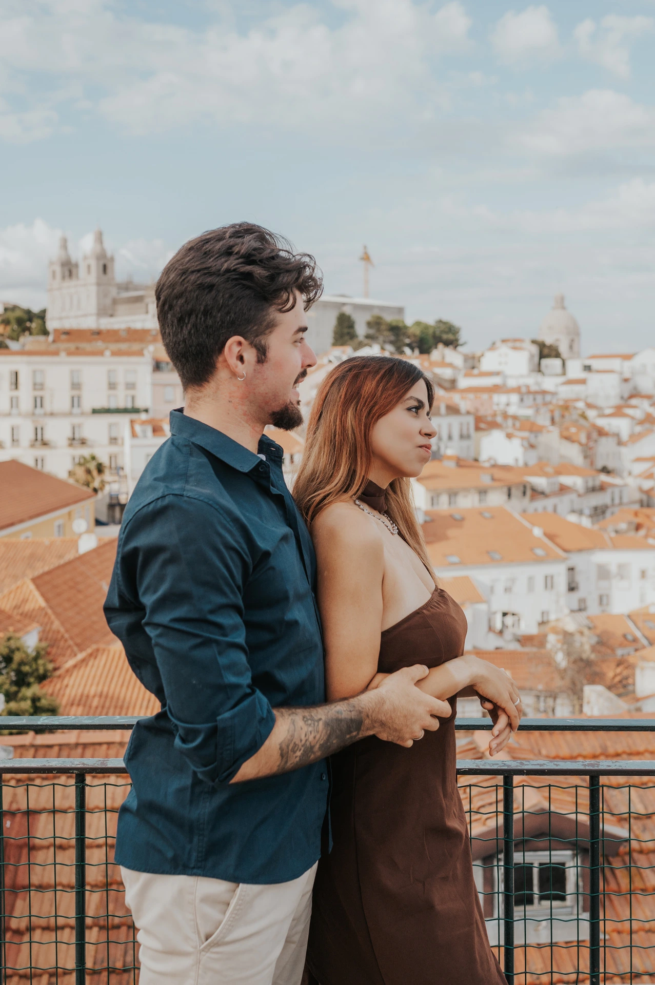 The couple standing side by side at the Portas do Sol railing during their engagement photoshoot in Lisbon.