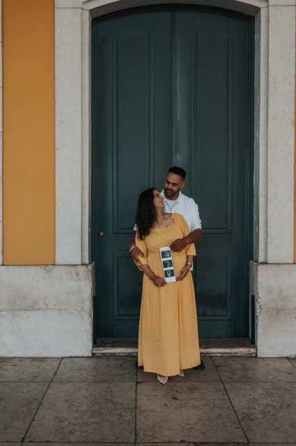 A close portrait with the ultrasound prints | Lisbon family and maternity photoshoot The expectant parents standing close together with the ultrasound photographs in the mother’s hands during their family and maternity photoshoot in Lisbon.