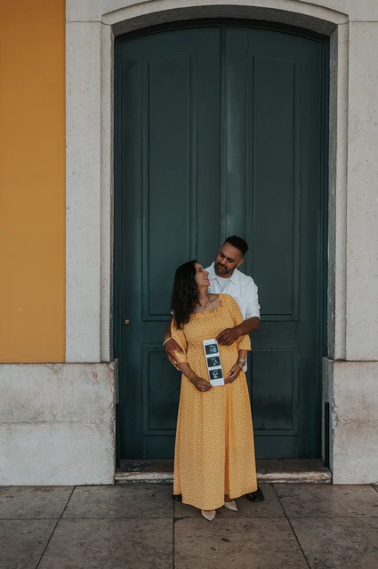 A close portrait with the ultrasound prints | Lisbon family and maternity photoshoot The expectant parents standing close together with the ultrasound photographs in the mother’s hands during their family and maternity photoshoot in Lisbon.