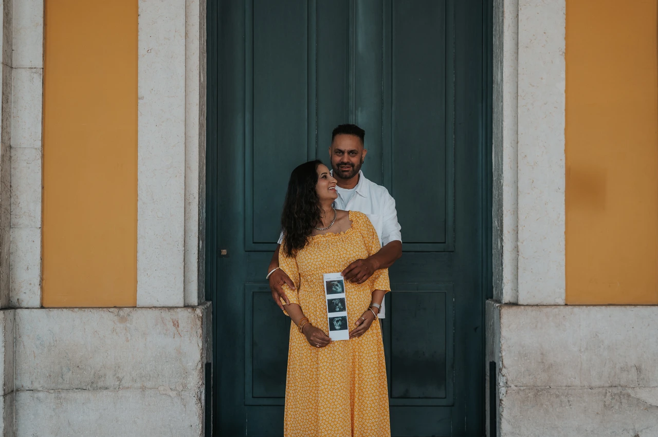 A close portrait with the ultrasound prints | Lisbon family and maternity photoshoot The expectant parents standing close together with the ultrasound photographs in the mother’s hands during their family and maternity photoshoot in Lisbon.