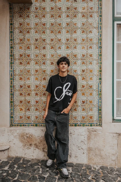 An individual portrait against Alfama’s tiles | Lisbon family photoshoot The older child standing beside the colourful patterned tile wall during their family photoshoot in Lisbon.