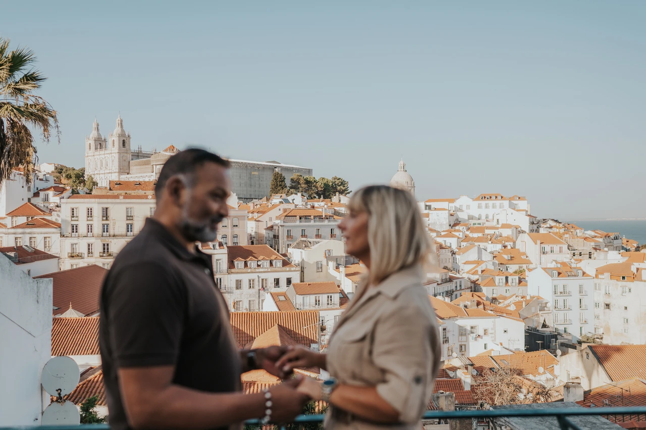 A soft portrait above the rooftops | Lisbon couple photoshoot A softly focused portrait of the couple facing each other with Lisbon’s rooftops behind them during their couple photoshoot in Lisbon.