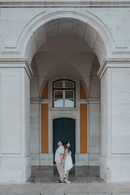 Couple beneath the arcades of Praça do Comércio in Lisbon