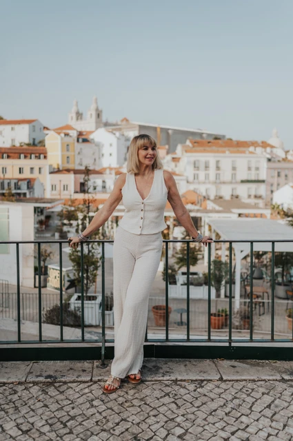 A quiet glance at Portas do Sol | Lisbon solo photoshoot The woman looking to the side while leaning on the Portas do Sol railing during her solo photoshoot in Lisbon.