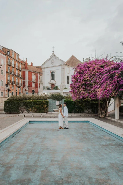 An embrace beside the garden pool | Lisbon couple photoshoot The couple embracing beside the shallow garden pool and flowering branches during their couple photoshoot in Lisbon.