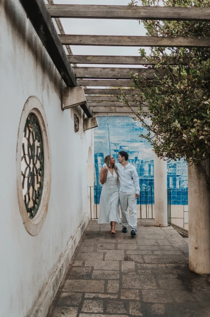 Hand in hand beneath the pergola | Lisbon couple photoshoot The couple holding hands beneath the garden pergola beside Portuguese tiles during their couple photoshoot in Lisbon.