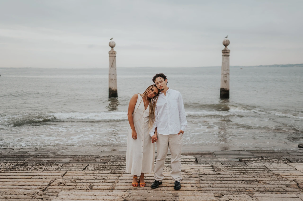 A quiet portrait beside the river | Lisbon couple photoshoot The couple leaning their heads together while standing on the waterfront steps during their couple photoshoot in Lisbon.