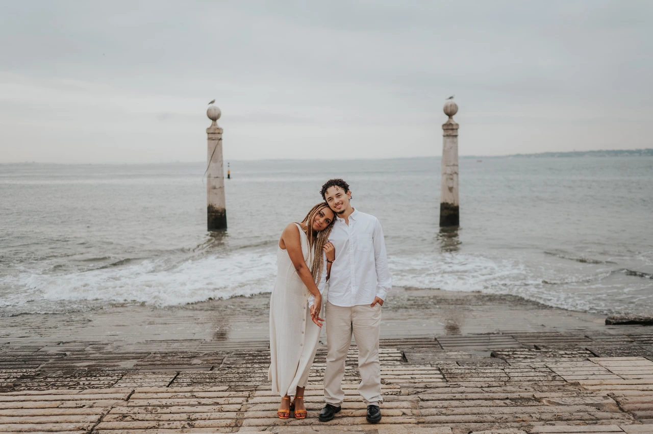 A quiet portrait beside the river | Lisbon couple photoshoot The couple leaning their heads together while standing on the waterfront steps during their couple photoshoot in Lisbon.