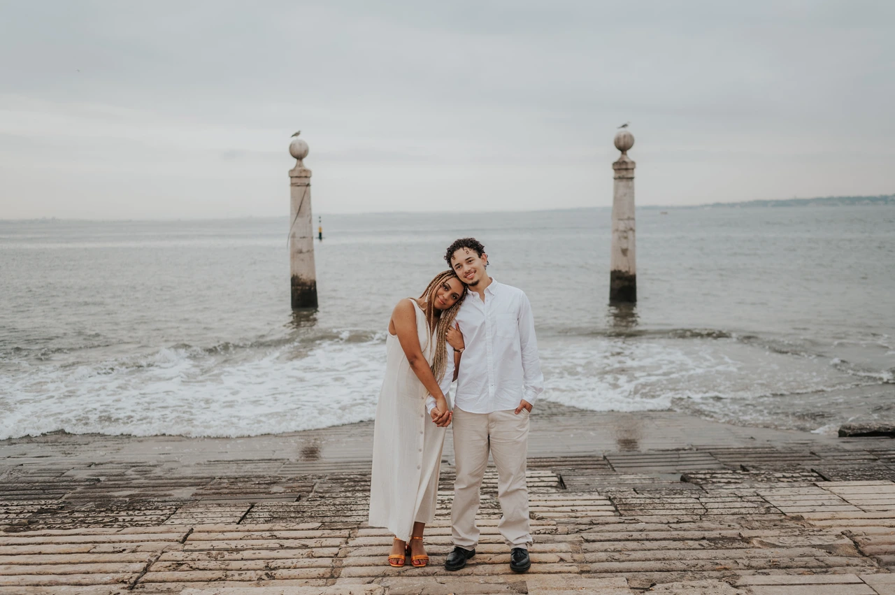 A quiet portrait beside the river | Lisbon couple photoshoot The couple leaning their heads together while standing on the waterfront steps during their couple photoshoot in Lisbon.