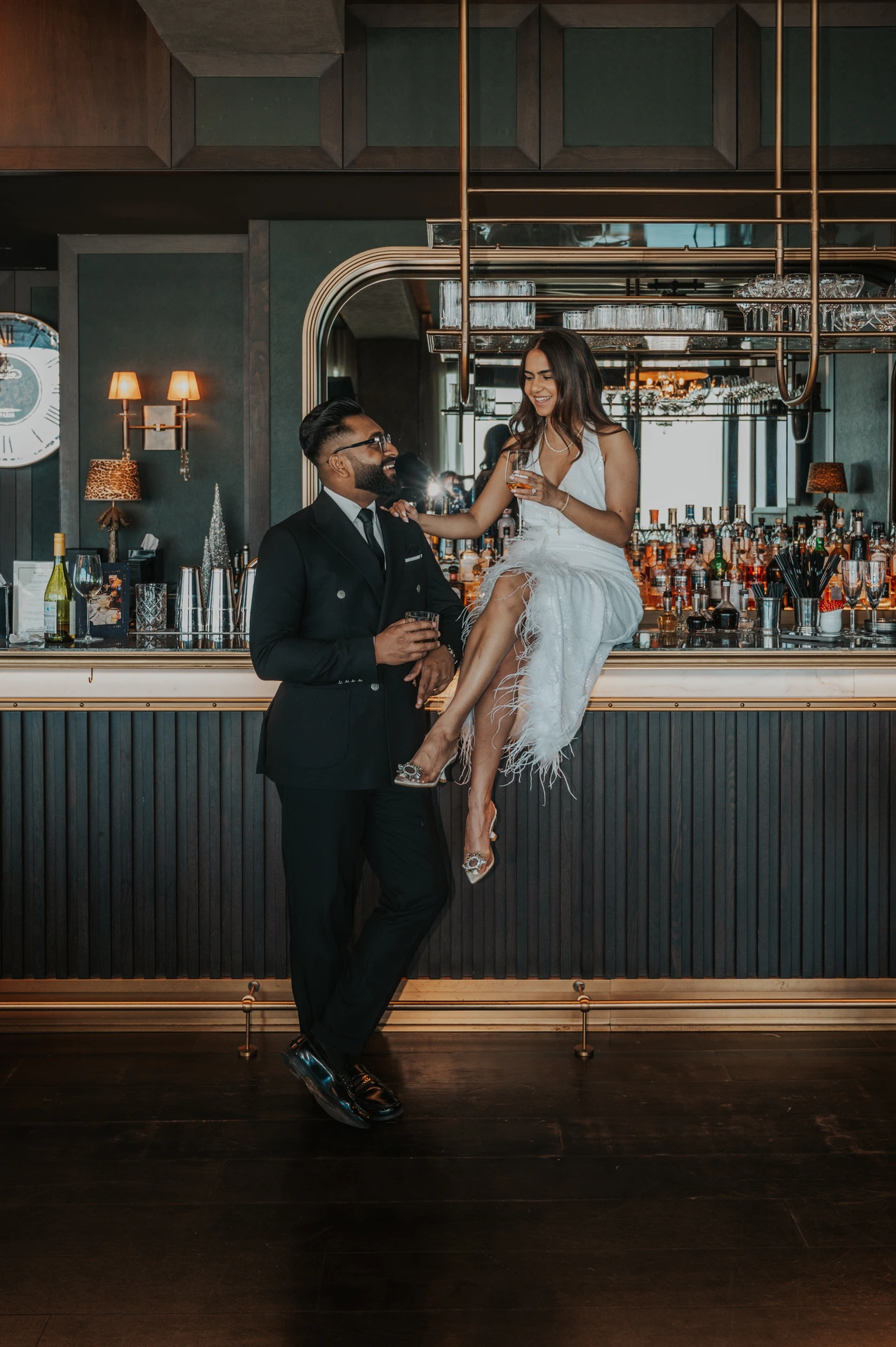 A stylish couple poses inside a modern Dubai bar during an indoor couple photoshoot.