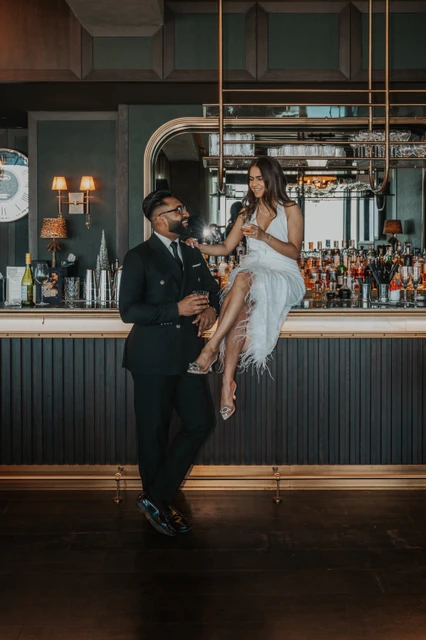 A stylish couple poses inside a modern Dubai bar during an indoor couple photoshoot.