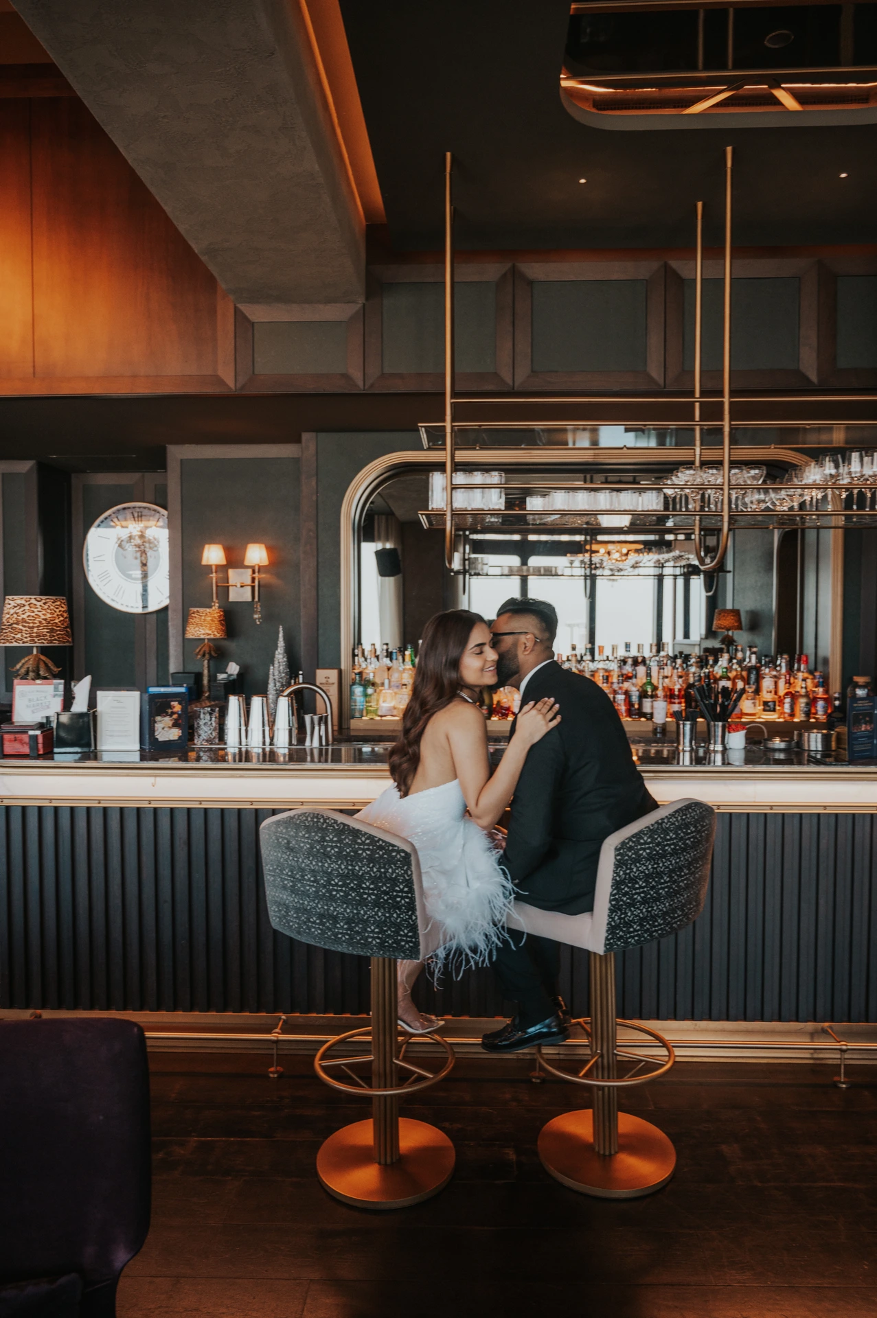 A couple sits close together in a cozy lounge and bar setting during an indoor Dubai session.