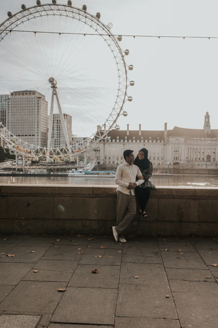 London couple photoshoot beneath the London Eye riverside view Couple together by the Thames at Westminster Pier, framed beneath the London Eye and riverside lights, during their London photoshoot.