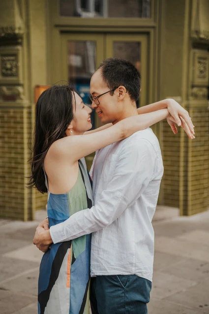 London couple photoshoot: a close embrace beside a green tiled doorway The couple embrace and smile with their faces close together in front of a green tiled doorway in Notting Hill during their London couple photoshoot.