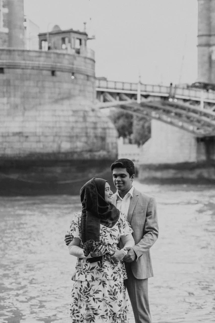 London engagement photoshoot: black-and-white portrait with roses Black-and-white portrait of a couple with roses beside the Thames below Tower Bridge during their London engagement photoshoot.