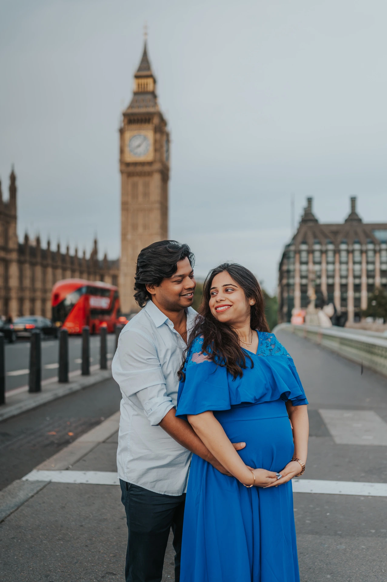 London maternity photoshoot with Big Ben behind the couple The couple look at each other with their hands on the baby bump, with Big Ben behind them, during a London maternity photoshoot.
