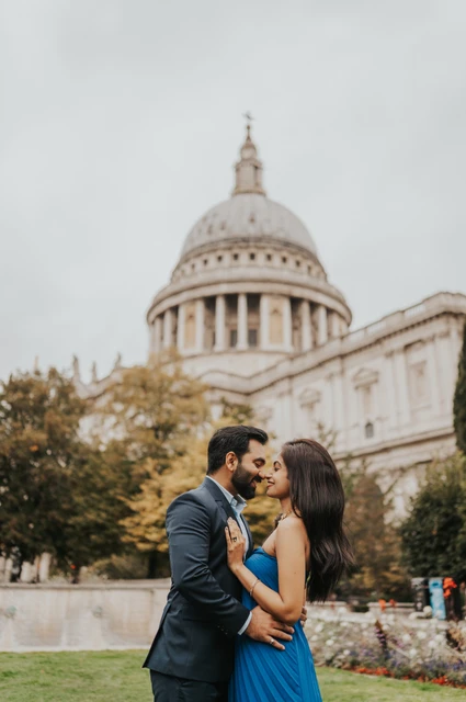 London proposal photoshoot: a kiss in Festival Gardens The couple sharing a kiss in Festival Gardens with St Paul’s Cathedral rising above the trees during their London proposal photoshoot.