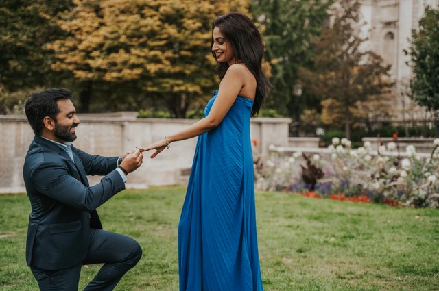 A closer view of the man kneeling with a ring and holding his partner’s hand in Festival Gardens during their London proposal photoshoot.