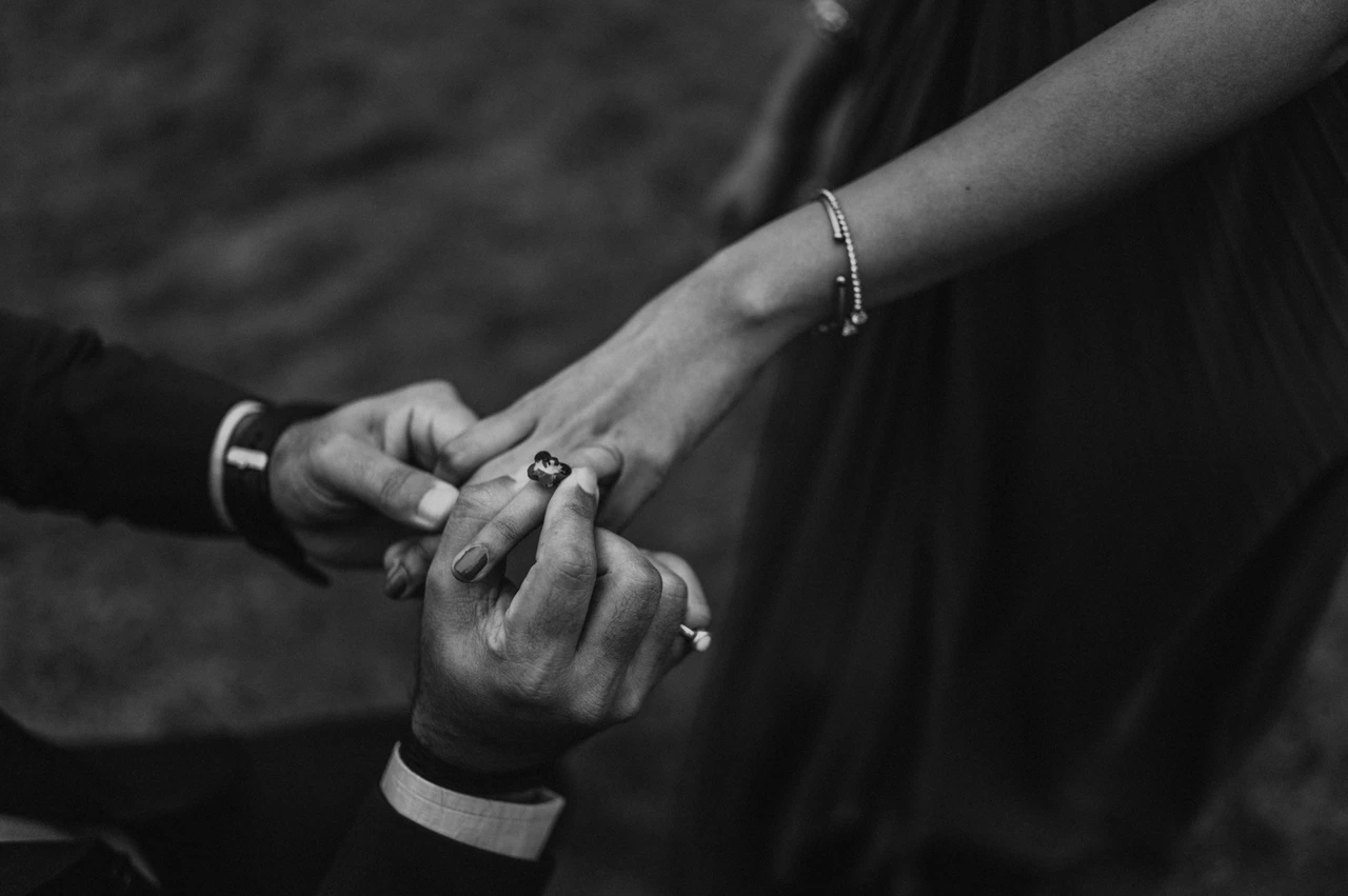 London proposal photoshoot: the engagement ring in black and white Black-and-white photograph of a close view of the engagement ring and the couple’s hands in Festival Gardens during their London proposal photoshoot.