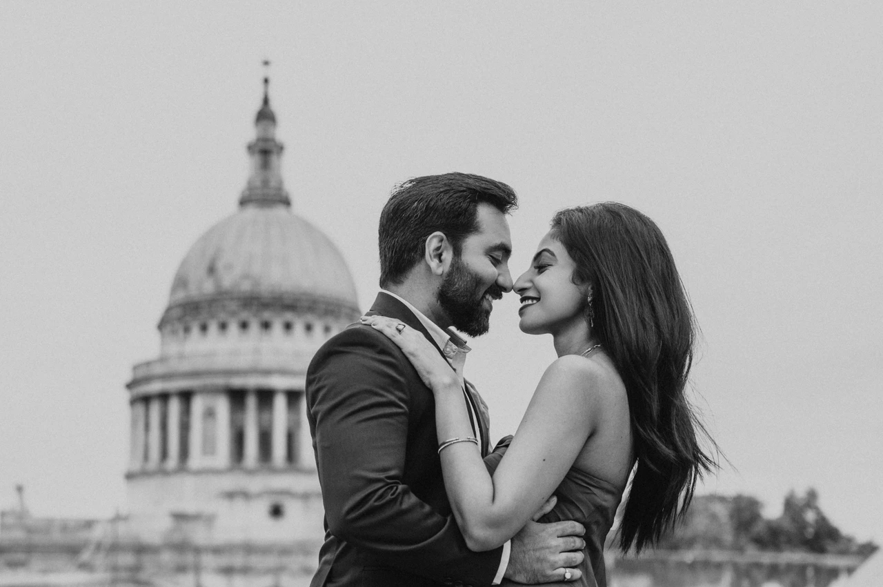London proposal photoshoot: a rooftop portrait in black and white Black-and-white photograph of a close rooftop portrait of the couple with St Paul’s Cathedral behind them during their London proposal photoshoot.