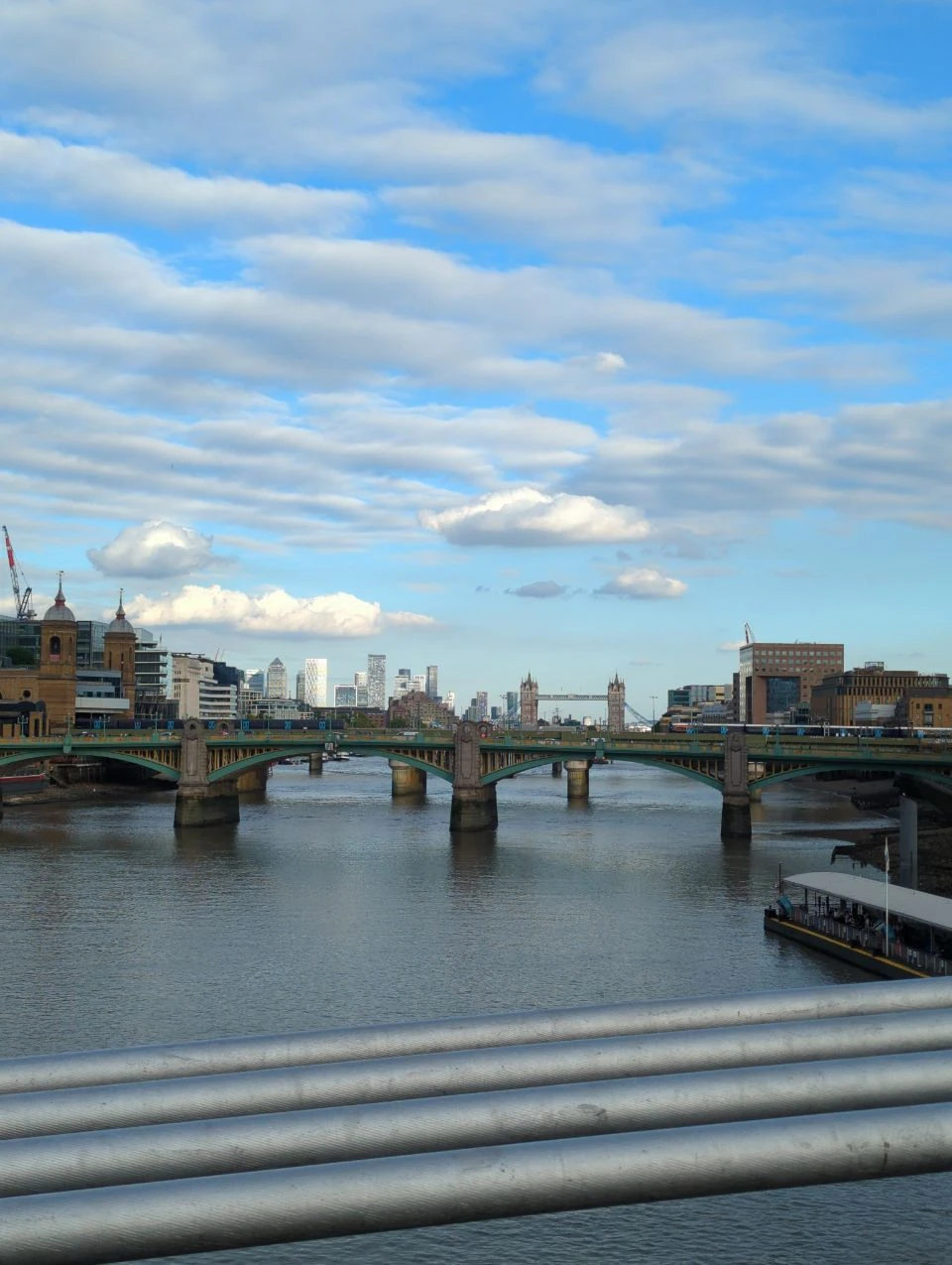 View along the Thames from Millennium Bridge with bridges and city buildings View along the Thames from Millennium Bridge with bridges and city buildings
