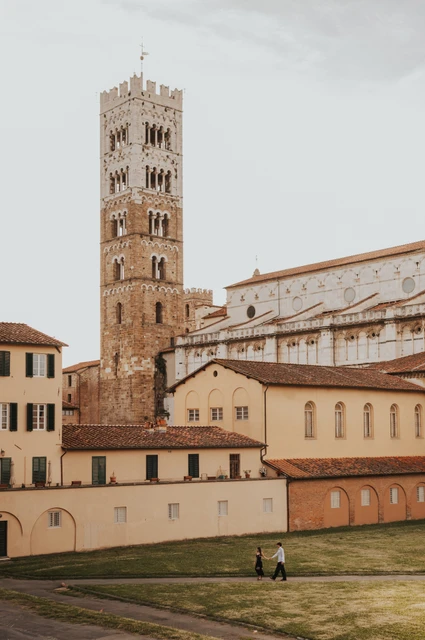 San Martino bell tower backdrop for a Lucca photoshoot The square bell tower of San Martino rises above the cathedral arches and neighbouring buildings. From Alice and Pablo’s Lucca anniversary photoshoot.