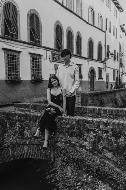 A canal-side anniversary photoshoot in Lucca, in black and white Black-and-white view of Alice and Pablo together on the brick bridge, with the canal below. From Alice and Pablo’s Lucca anniversary photoshoot.