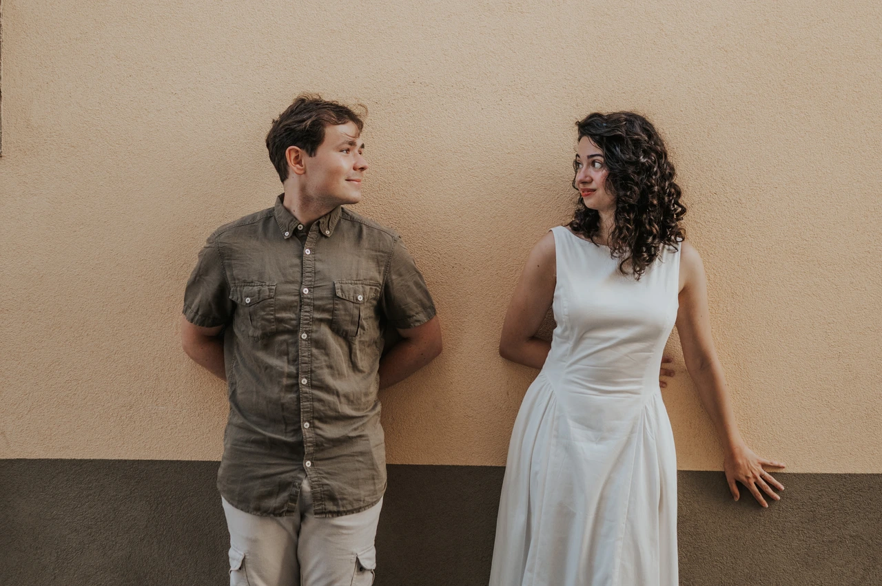 Lucca couple photoshoot: a warm ochre wall in the old town The couple standing apart against a warm ochre wall in the old town during a couple photoshoot in Lucca.