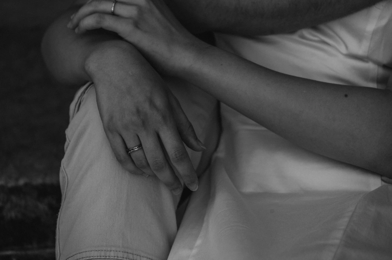 Lucca couple photoshoot: a detail of hands and a white dress in black and white Black-and-white photograph of a close detail of the couple’s hands against the folds of the woman’s white dress beside the Duomo di San Martino during a couple photoshoot in Lucca.