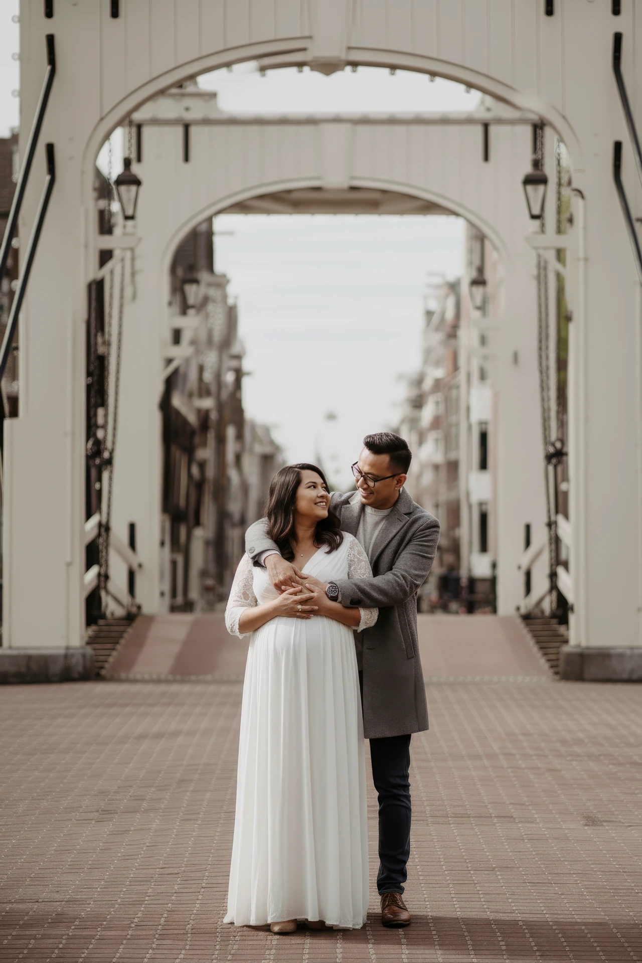 Maternity photoshoot Amsterdam A couple doing a maternity photoshoot at the Magere brug in Amsterdam
