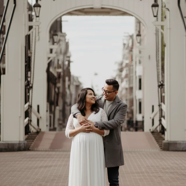 Maternity photoshoot Amsterdam A couple doing a maternity photoshoot at the Magere brug in Amsterdam