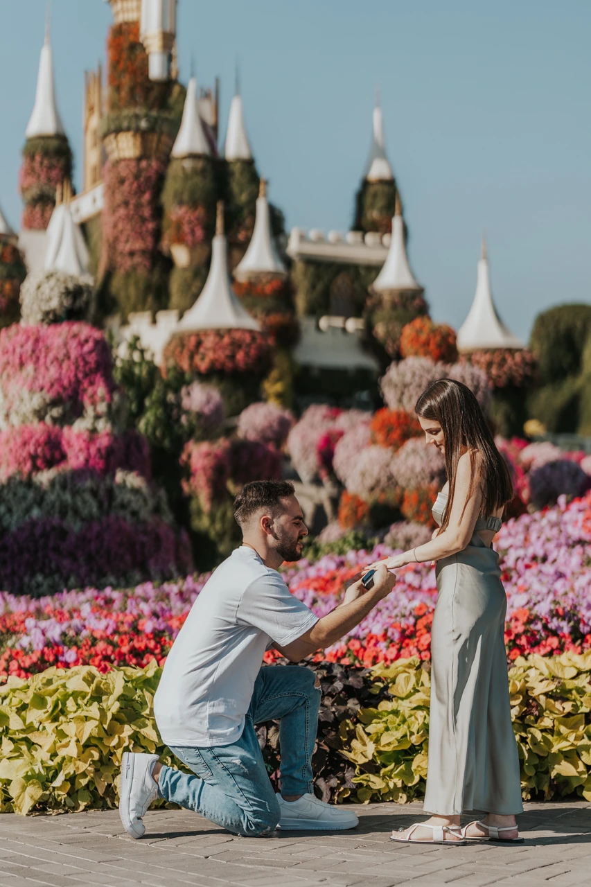 Miracle Garden proposal Dubai couple A couple embracing after a proposal in Dubai Miracle Garden during a romantic outdoor photoshoot session.