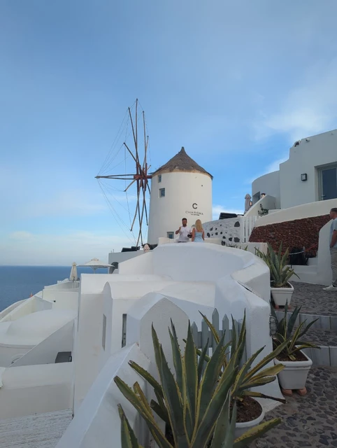 White windmill and terraces overlooking the sea in Oia