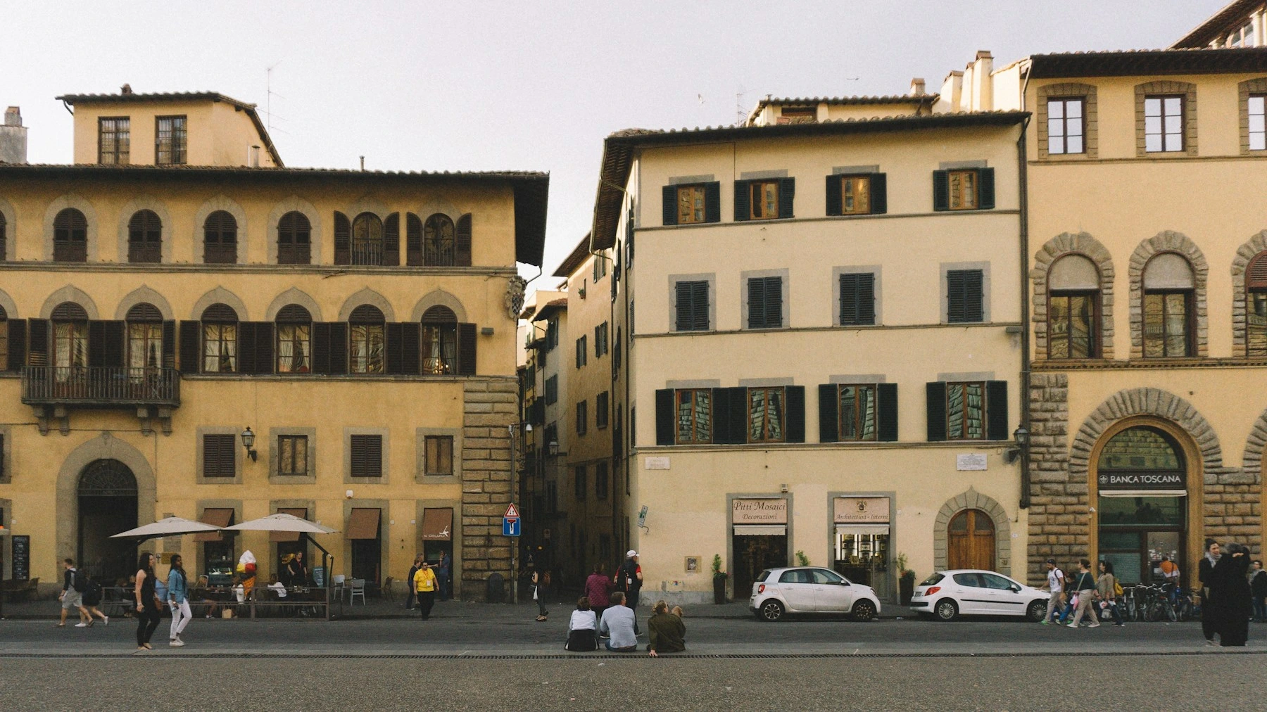 People walking past shuttered buildings near Palazzo Pitti in Florence