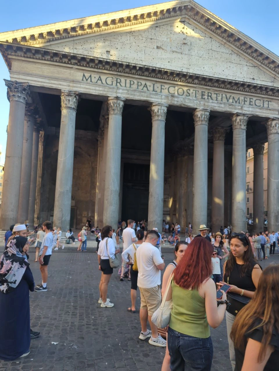 Visitors gather below the sunlit pediment and tall columns of the Pantheon, a monumental finish for a Rome photoshoot route.