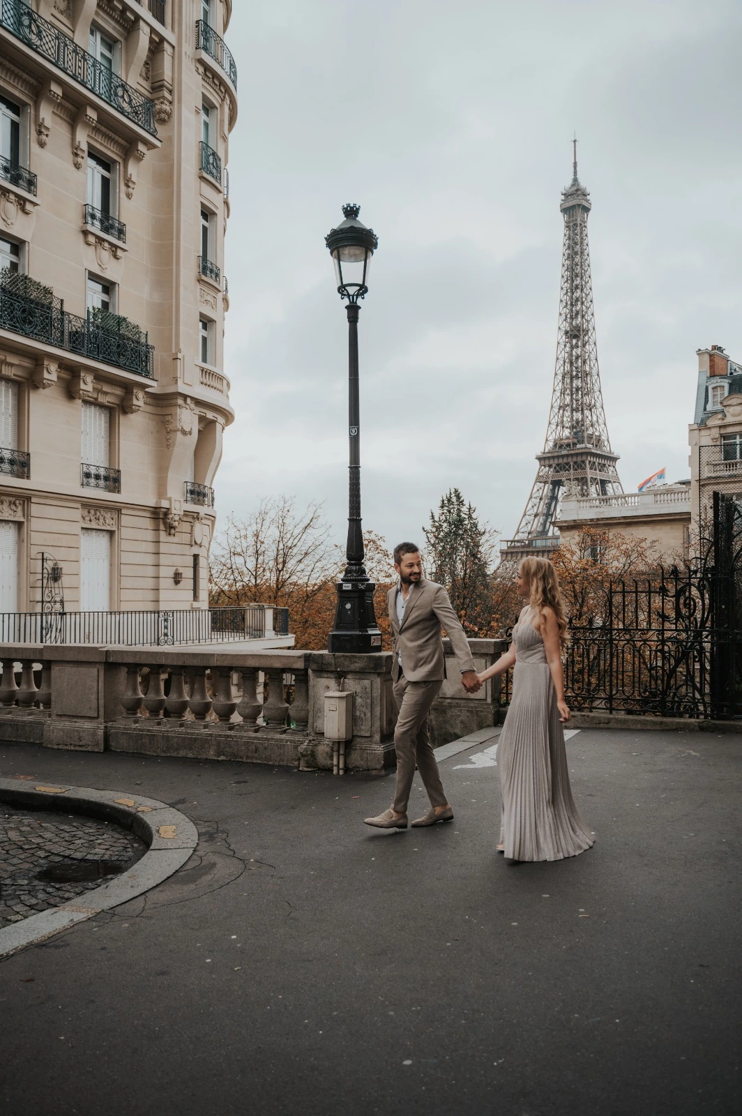 Una pareja en una calle de París con vistas a la torre Eiffel.