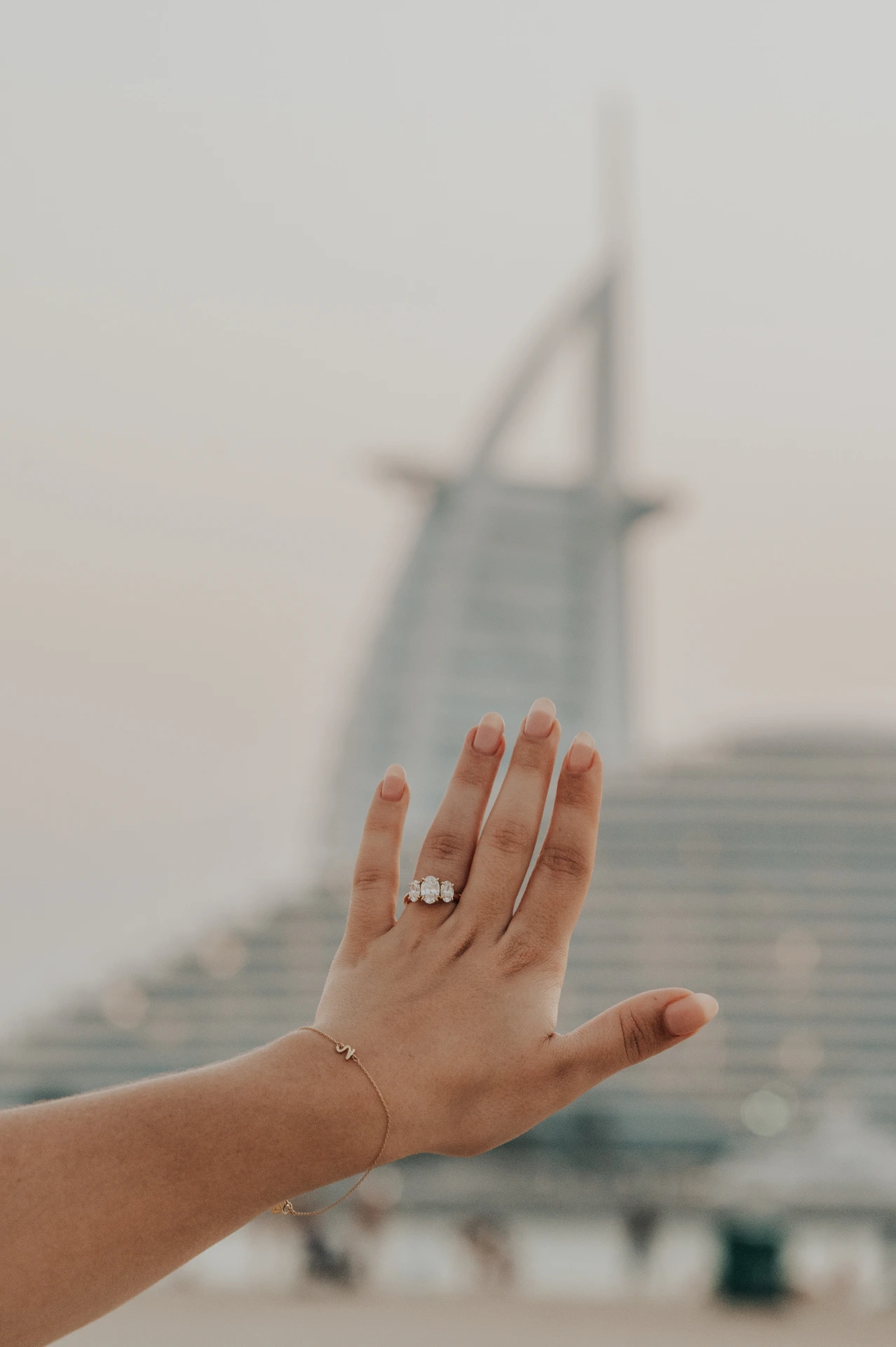 Un couple photographié sur la plage près du Burj Al Arab à Dubaï pendant leur demande en mariage, capturé par un photographe spécialisé.